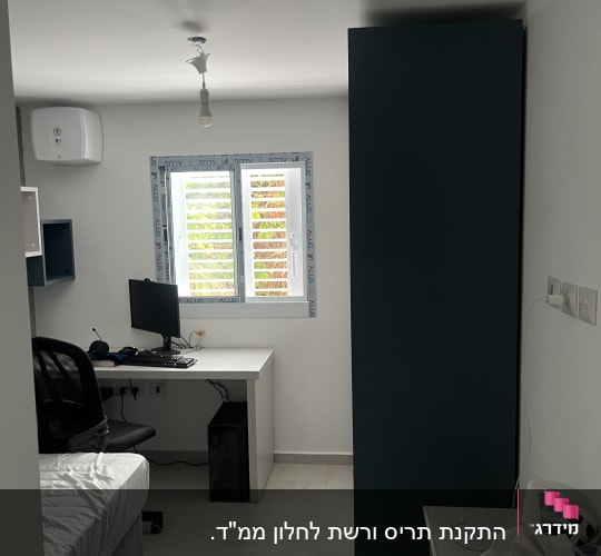 חלון עם תריסי אלומיניום בחדר עבודה